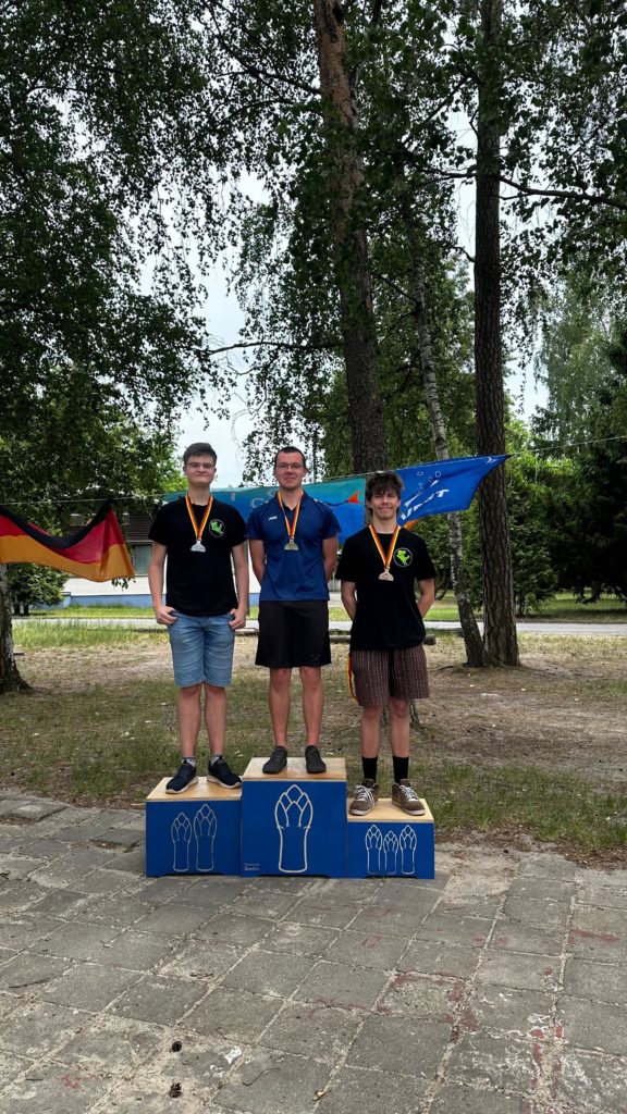 Podium bei der Siegerehrung der Disziplin "M-Kurs" für die Männliche Jugend. Matteo steht auf Position 2, Nick steht auf Postion 3. Alle haben ihre jeweiligen Medaillen der Deutschen Meisterschaft um den Hals.